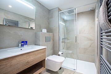 A bathroom with a toilet a sink and a shower