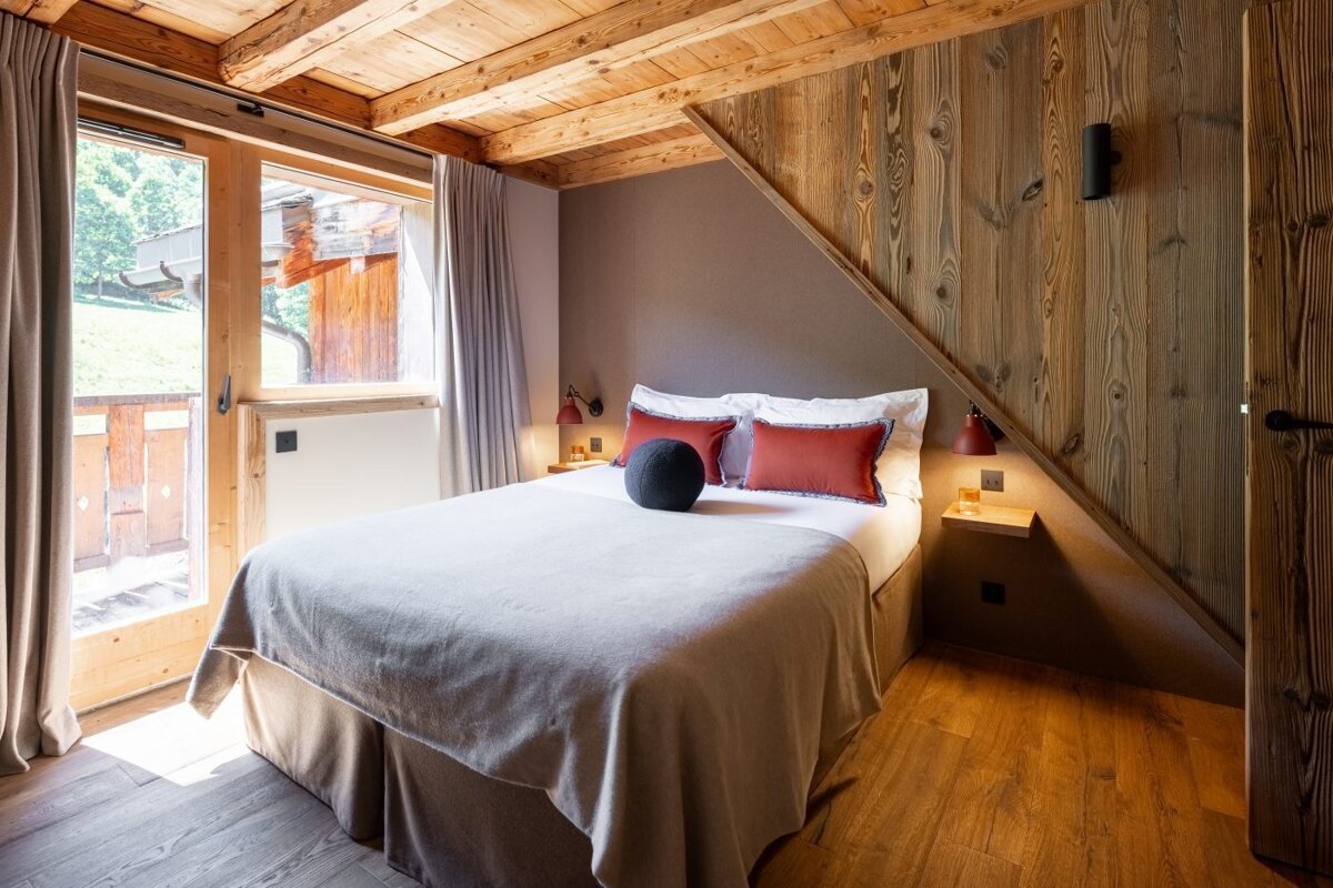 A bedroom with a bed and a wooden wall