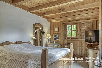 A bedroom with a bed and a television from mountain base immobilier real estate