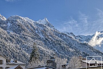 A snowy mountain range with a house in the foreground
