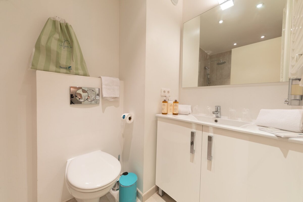 A bathroom with a toilet and a blue trash can