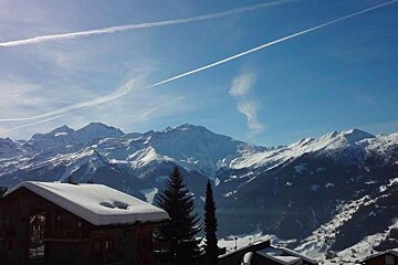 A snowy mountain range with a blue sky in the background