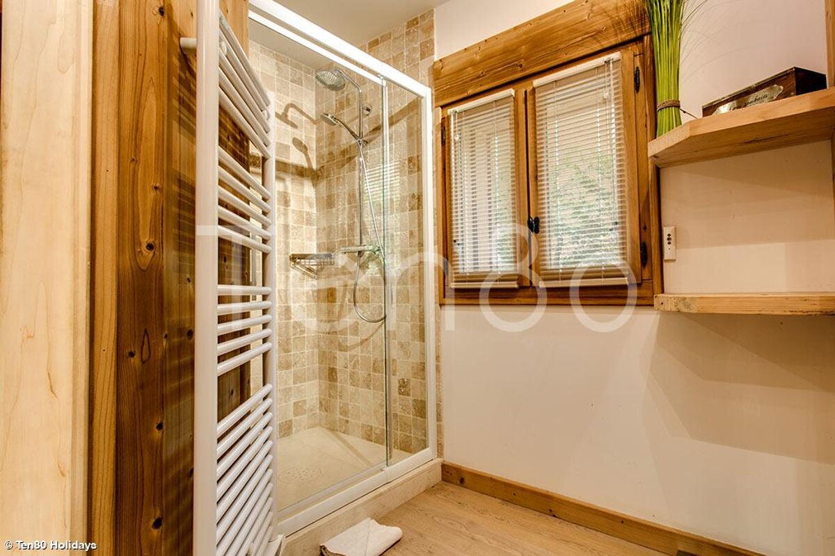 A bathroom with a walk in shower and a towel rack