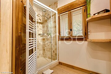 A bathroom with a walk in shower and a towel rack