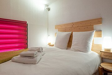 A bed with white sheets and pillows in a bedroom