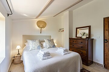 A bedroom with a bed dresser and mirror