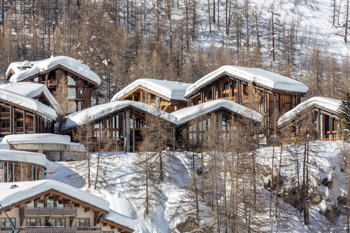 A row of snow covered houses on a snowy hillside