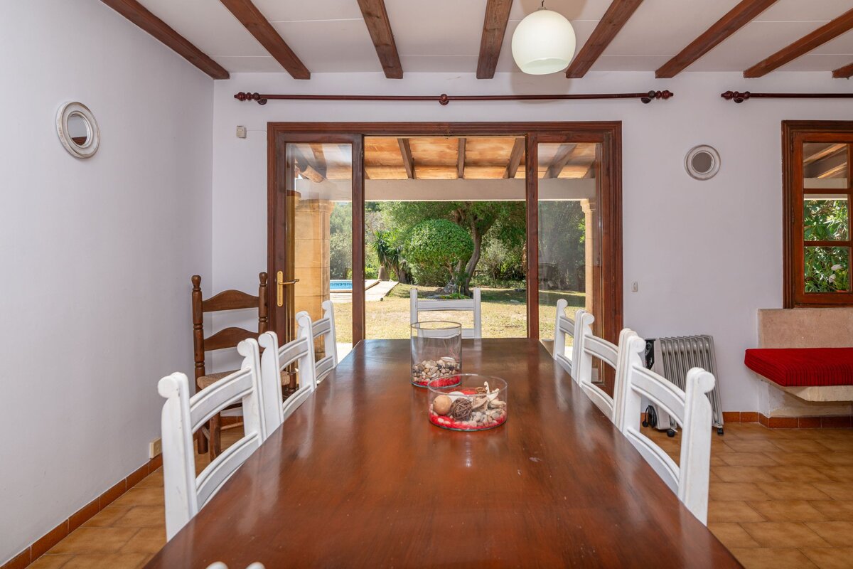 A dining room table with a vase of seashells on it