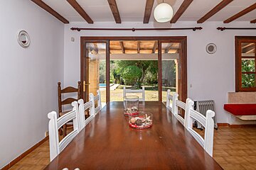 A dining room table with a vase of seashells on it