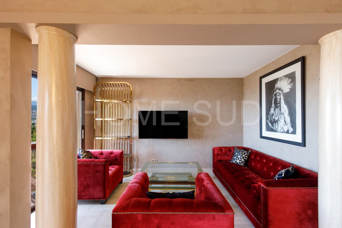 A living room with red furniture and a picture of a native american on the wall