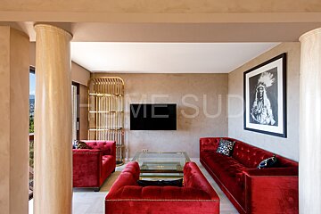 A living room with red furniture and a picture of a native american on the wall