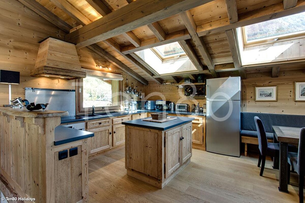 A kitchen with wooden cabinets and a stainless steel refrigerator