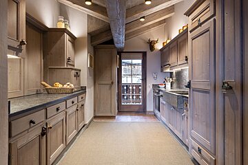 A kitchen with a basket of bread on the counter