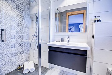 A bathroom with a sink and a walk in shower