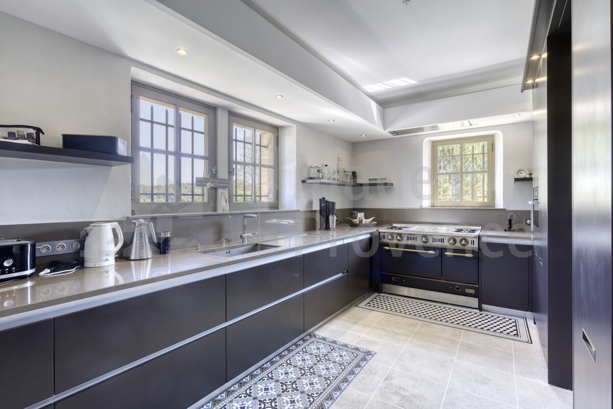 A kitchen with black cabinets and a stove top oven