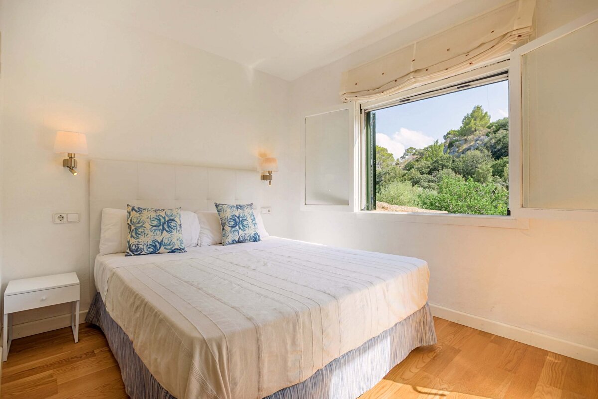 A bedroom with a large bed and a window