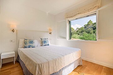 A bedroom with a large bed and a window