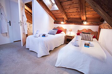 A bedroom with two twin beds and a nightstand