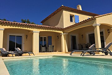 A large house with a swimming pool in front of it