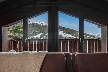A couch in front of a window with a view of mountains