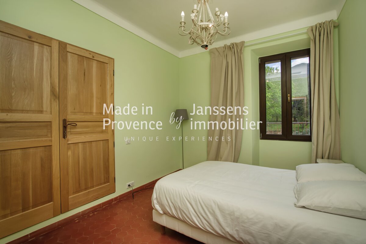 A bedroom with green walls and a bed made in provence by immobilier