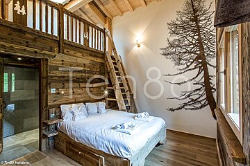A bedroom with a bed and a ladder and the number ten80 on the wall