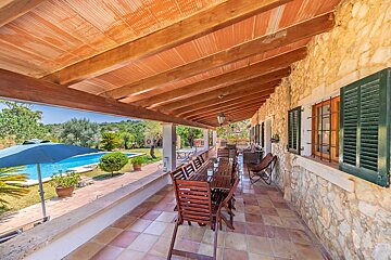 A patio with a table and chairs and a blue umbrella