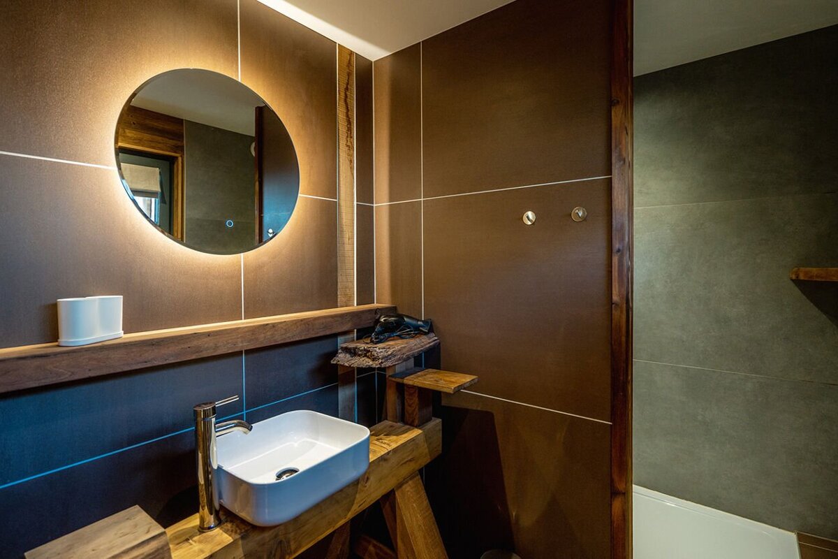 A bathroom with a sink and a round mirror