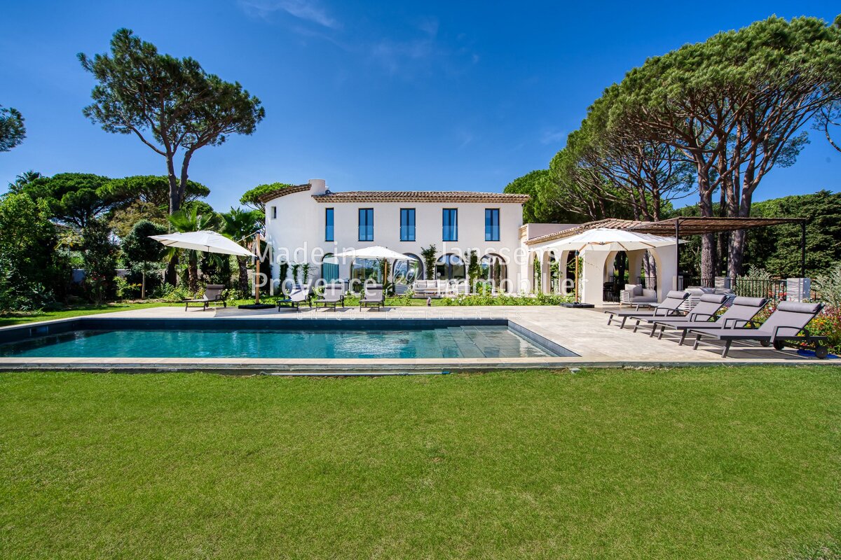 A large white house with a large swimming pool in front of it