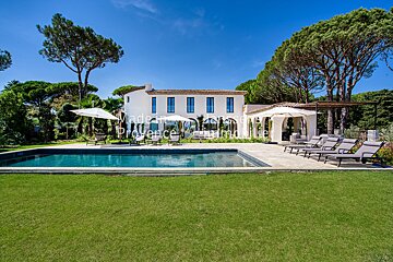 A large white house with a large swimming pool in front of it