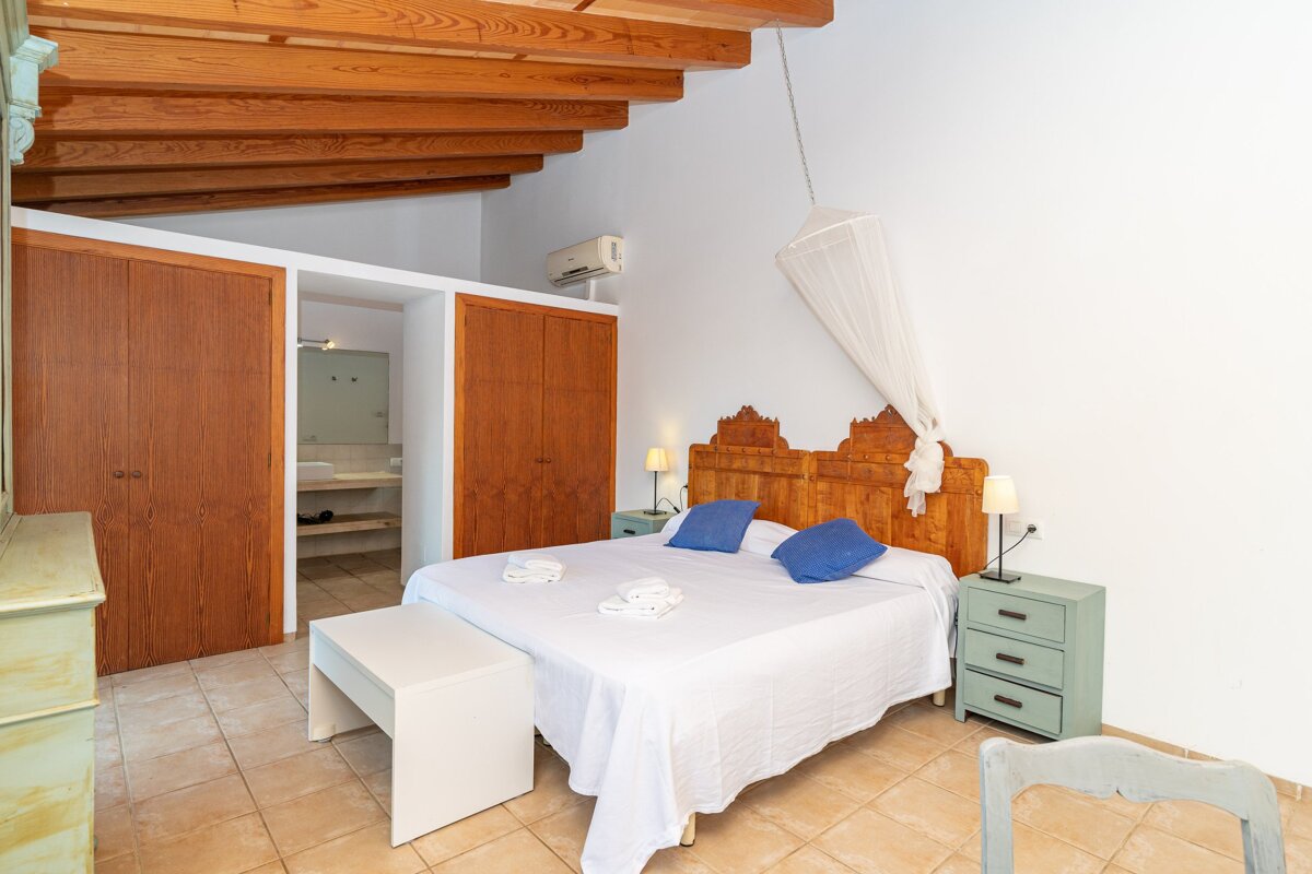 A bedroom with a canopy bed and blue pillows