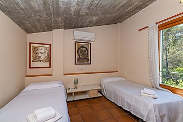 A bedroom with two beds and two paintings on the wall