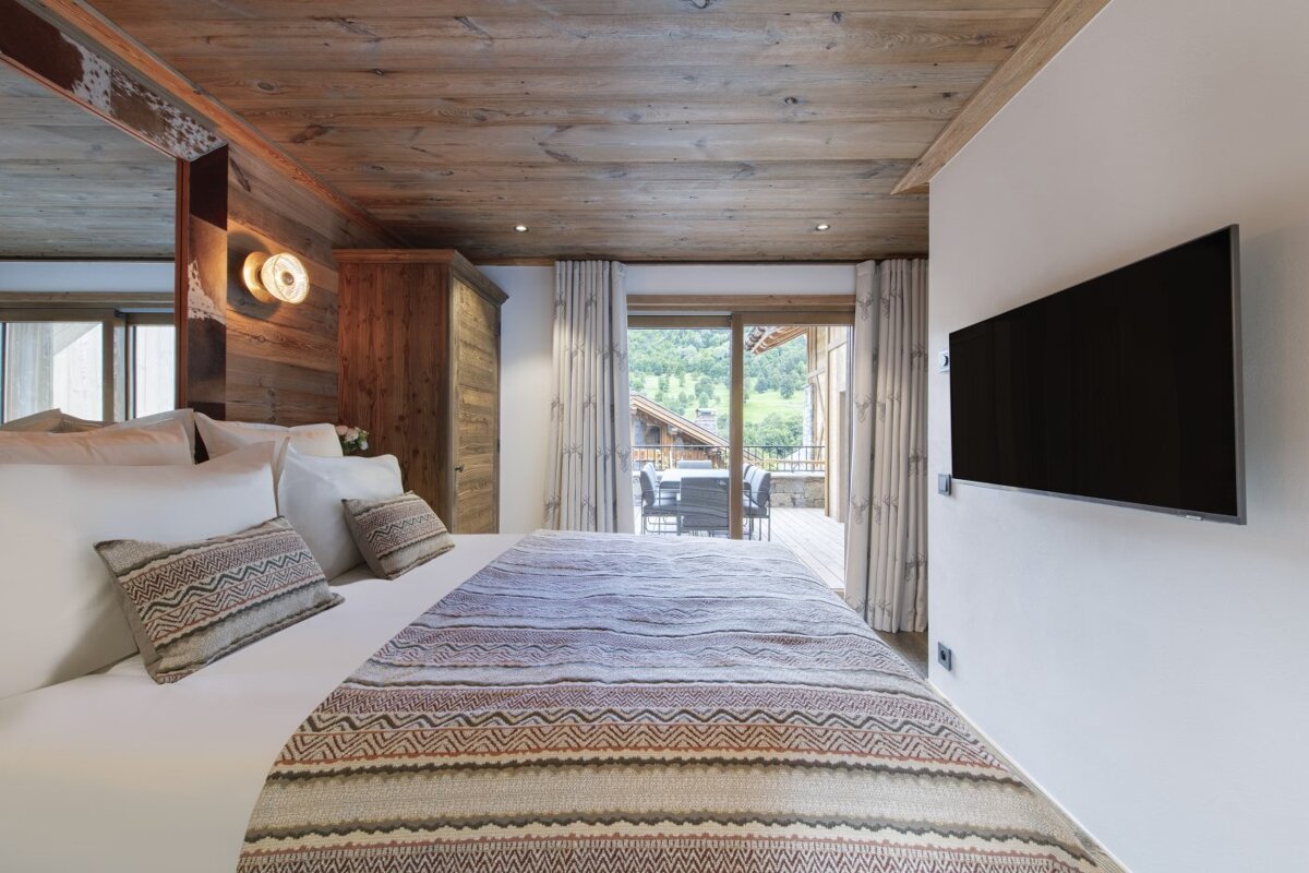 A bedroom with a large bed and a flat screen tv