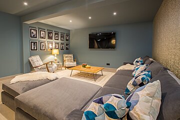 A living room with a couch and chairs and a flat screen tv