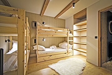 A bedroom with bunk beds and a rug on the floor