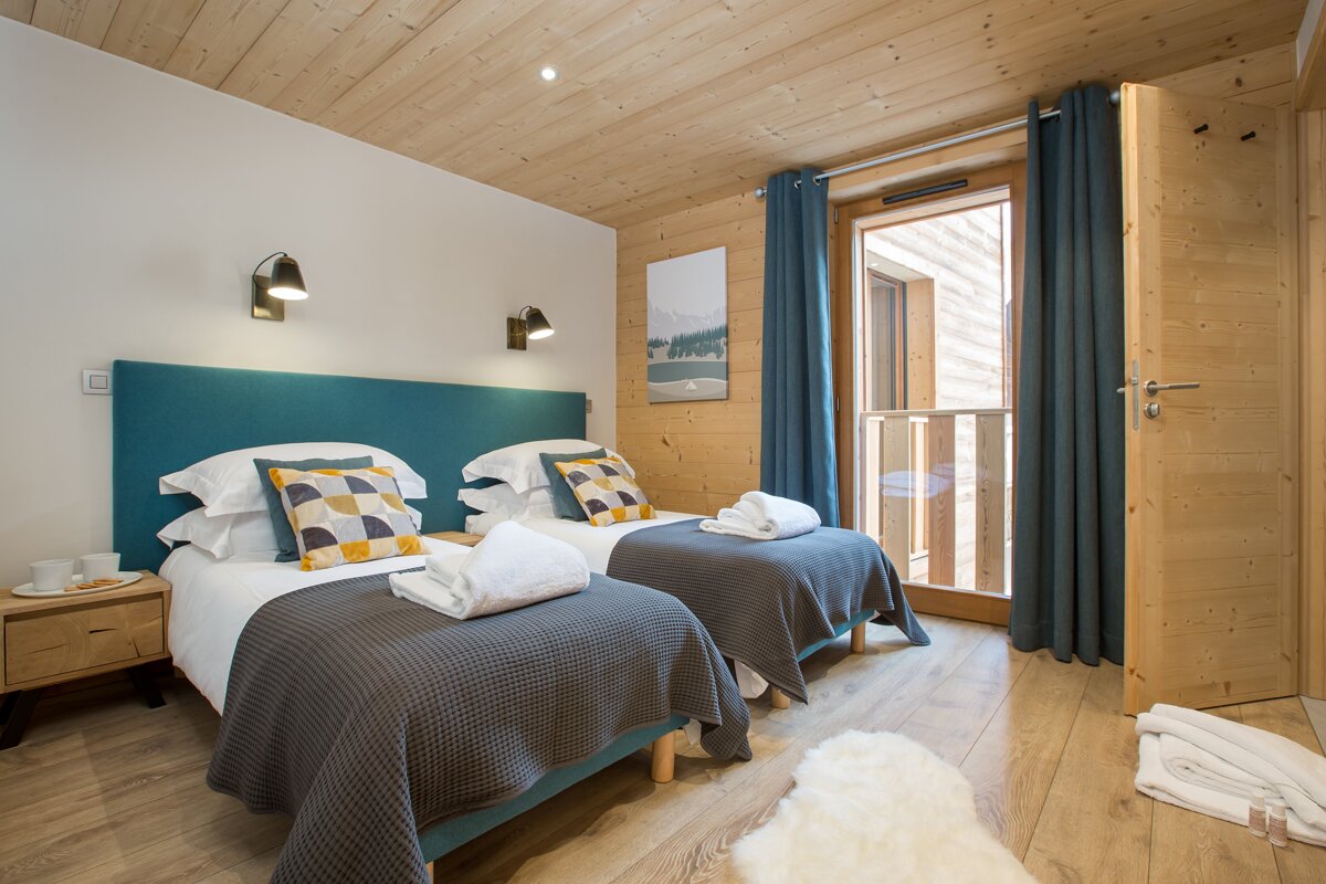 A bedroom with two beds and a painting on the wall