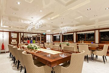 A dining room with a long table and chairs