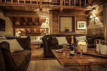 A bottle of champagne sits on a wooden table in a living room