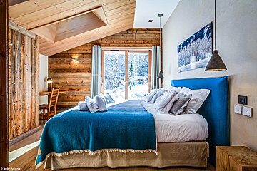 A bedroom with a large bed and a blue headboard