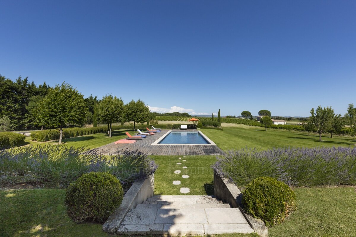 A large swimming pool surrounded by lavender and trees