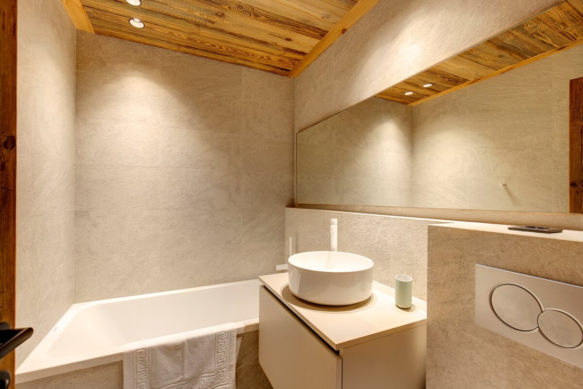 A bathroom with a bathtub sink and mirror