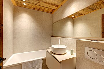 A bathroom with a bathtub sink and mirror