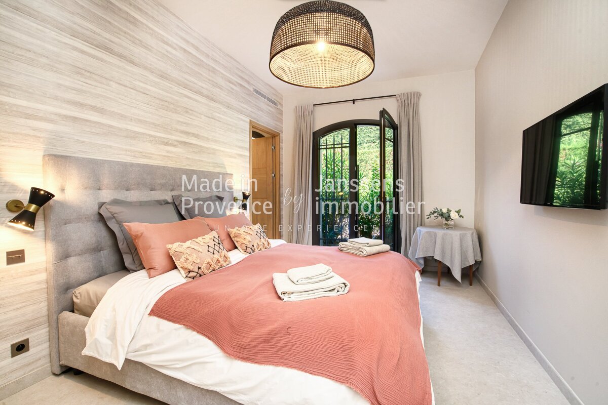 A bedroom with a bed and a television says made in provence