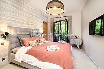 A bedroom with a bed and a television says made in provence