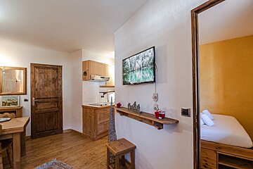 A small room with a flat screen tv on the wall
