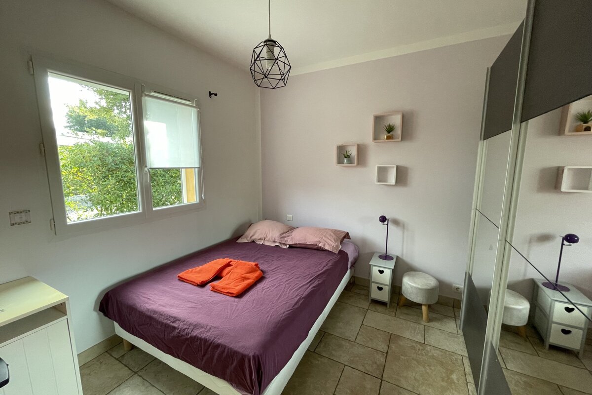 A bedroom with a purple bed and a mirror