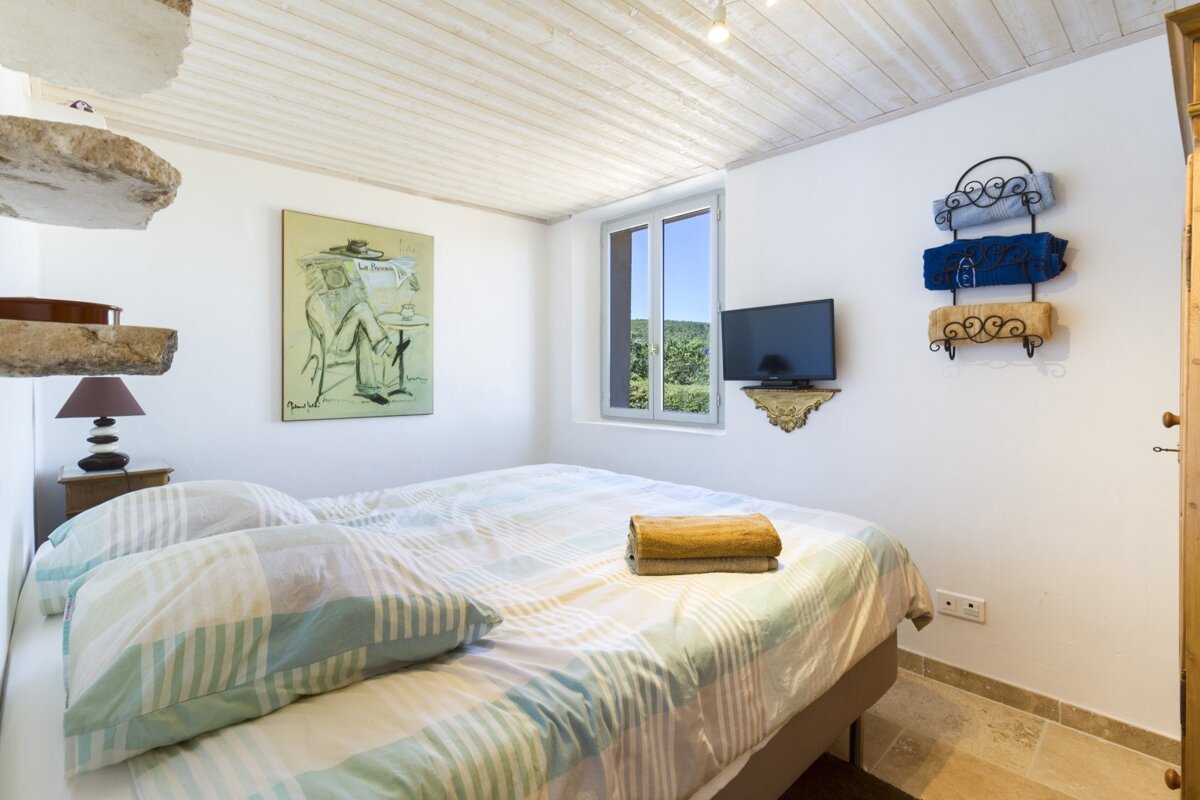 A bedroom with a bed and a painting on the wall