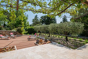 A deck with chairs and trees in the background