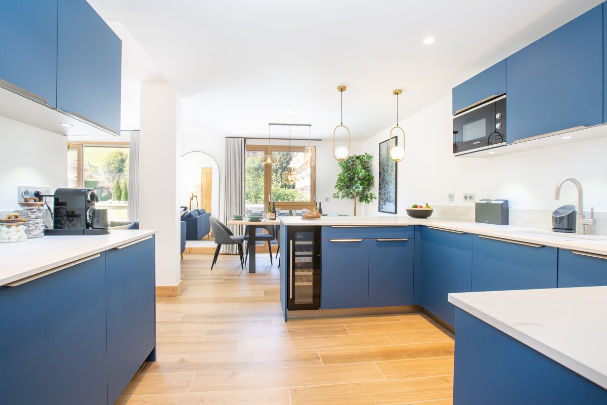 A kitchen with blue cabinets and white counter tops