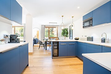 A kitchen with blue cabinets and white counter tops